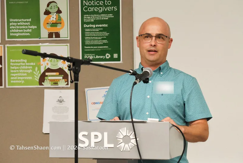 A speaker in a teal shirt at the podium