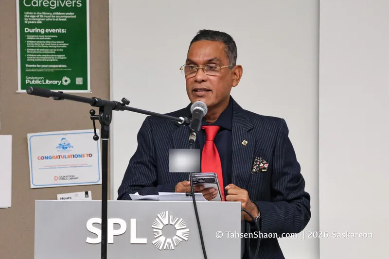 A speaker in a red tie at the podium