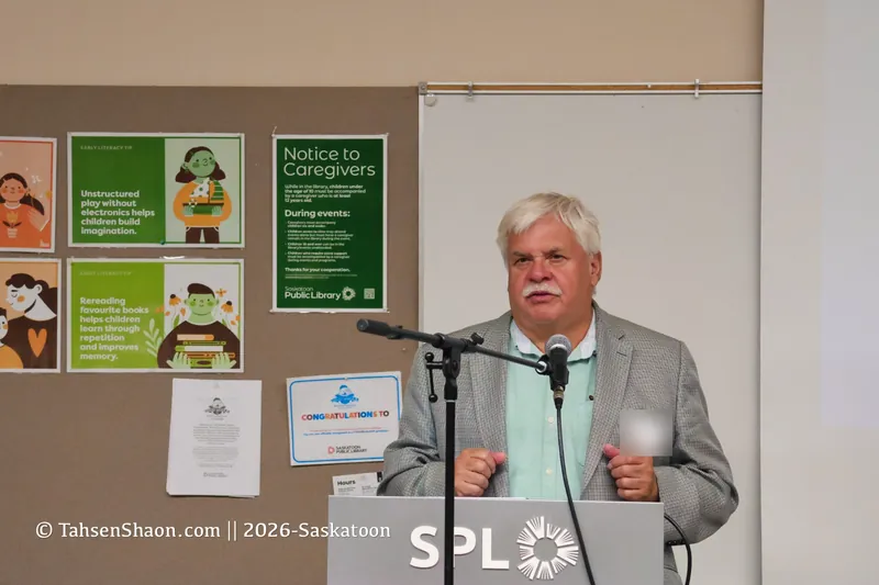 A speaker in a grey jacket at the podium