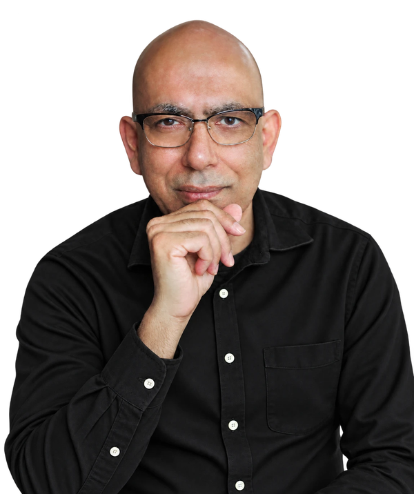 Portrait of Sukant Ratnakar in glasses and a dark shirt, chin resting on one hand